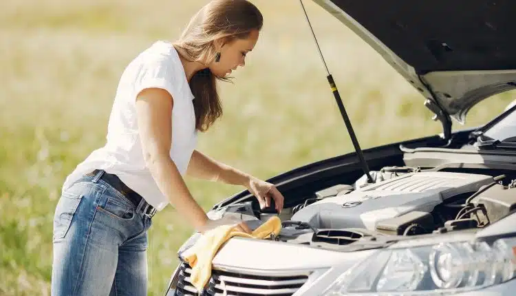 Troubled young woman near broken automobile in countryside during car accident